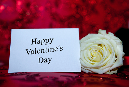 White Rose with a hole to the day of the holy valentine on a red background.の写真素材