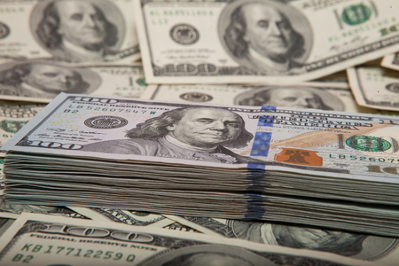 stack of dollars against the backdrop of moneyの写真素材