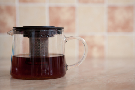 Glass teapot and glass cup with tea on the table.の写真素材