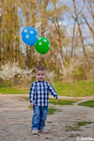 Happy little boy holds balloons, boy with balls.の写真素材