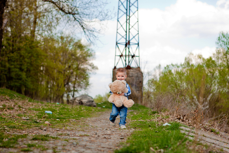 Boy in a park with a teddy bear.の写真素材