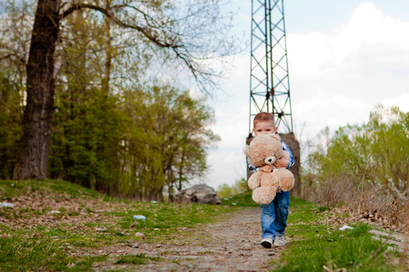 Boy in a park with a teddy bear.の写真素材