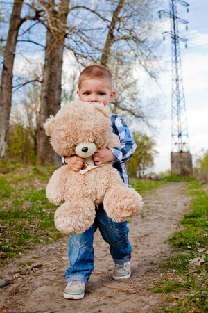 Boy in a park with a teddy bear.の写真素材