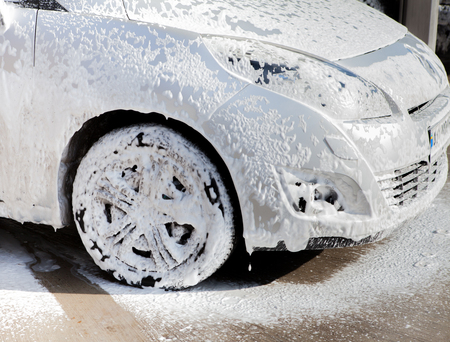 Car washing concept. Car in foam. wheel car in the foam on the sinkの写真素材