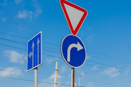 A sign that shows the road and turn only right to the background of a brilliant blue sky.の写真素材