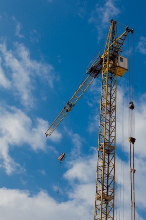 Industrial background with construction crane over blue cloudy sky.の写真素材