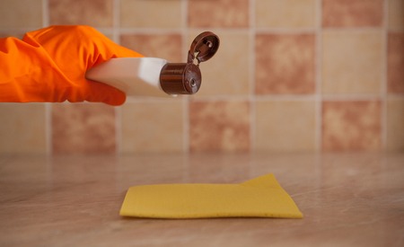 Woman hand holding yellow sponge and pouring cleaning liquid on it. housekeeping and hygiene concept.の写真素材