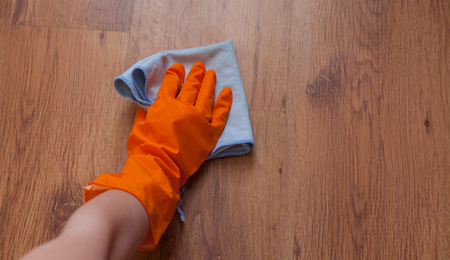 A woman hand Using blue rags wipe the wooden floor.の写真素材