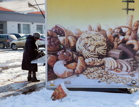 Happy senior woman 70-80 year old buys bread in a kiosk on street.Healthy eating.の写真素材