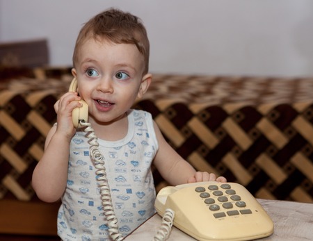 childhood and toy concept - curious child playing with phone.の写真素材