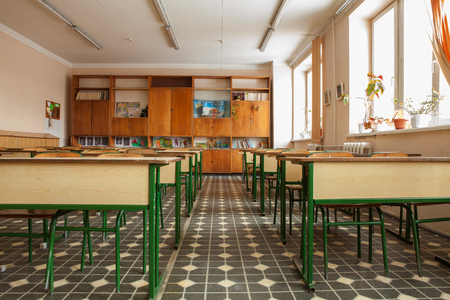 Student tables with different textbooks, copybooks in school college classroom background. Interior of school classroom. Education background.の写真素材