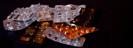blank plate of pills on a black background, place for text.の写真素材