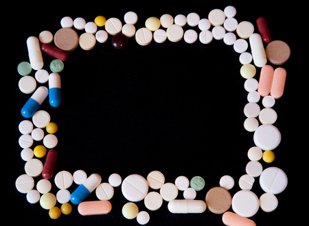 Frame of pills on a dark background with free space for text, top view.の写真素材