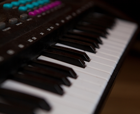 closeup black piano keys, black piano isolated, side view of an instrument. learning to play at home. black grand digital piano. piano keyboard. concert concept. selective focus.の写真素材