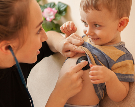 Selective focus Professional pediatrician examining to a little boy. Doctor using a stethoscope to listen to infant's chest checking heartbeat or lung.の写真素材