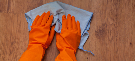 A woman hands Using blue rags wipe the wooden floor.の写真素材