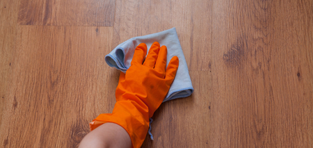 A woman hand Using blue rags wipe the wooden floor.の写真素材