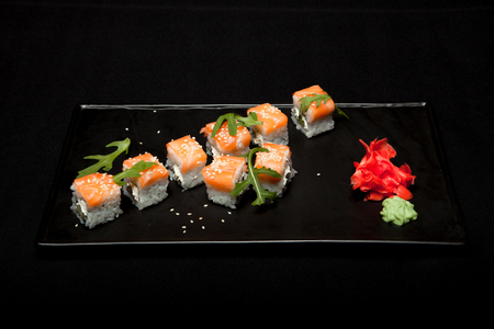 Sushi roll with salmon and avocado on plate on black background top view.の写真素材