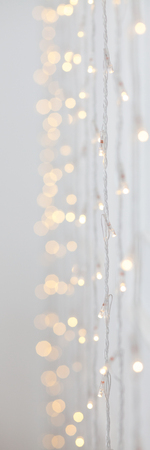 Soft colorful bokeh background. Luminous garlands of electric lights. Wood wall. Dark night. Festive party. Christmas or New year. Blurry abstraction. Low depth of field. Copy space to add your textの写真素材