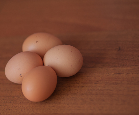 Close up of fresh chicken egg on wooden table with copy spaceの写真素材