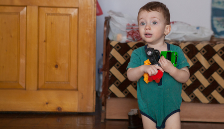 little boy plays with toy car at homeの写真素材