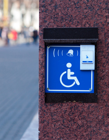Handicapped access entrance pad mounted to a wall. Sign a button for a visa for people with disabilitiesの写真素材