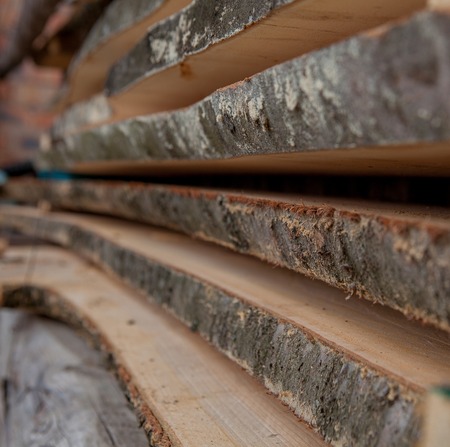 Folded wooden planks in a sawmill. Piled boards as texture.の写真素材