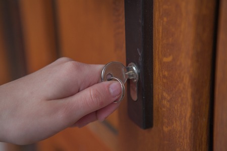Locking up or unlocking door with key in hand.の写真素材