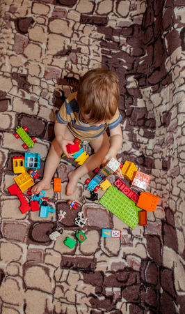 Sweet little boy building tower from cubes at home.の写真素材