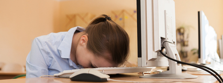 Portrait of tired business woman fell asleep on computer keyboard.の写真素材