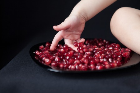 Cute little boy eating a red pomegranate,health nutrition conceptの写真素材