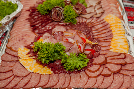 Assorted cold meats on a plate, meat cut on a tray.の写真素材