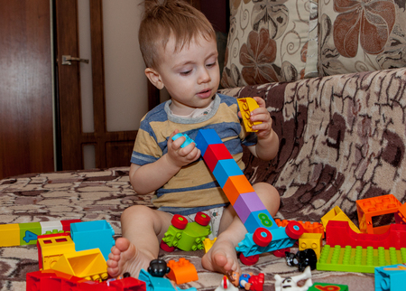 Sweet little boy building tower from cubes at home.の写真素材