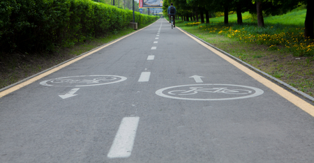 Painted signs on asphalt for bicycle dedicated lanes. A separate bike path in the city, cyclists on the cycle track.の写真素材