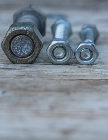 Bolts and nuts on the wooden table for commercial use are used, copy space.の写真素材