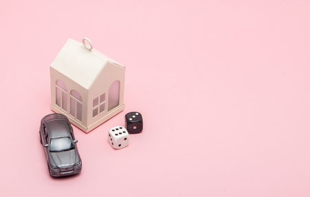 Casino, gambling and fortune concept. Model house and car, games dice on pink background with copy space.の写真素材