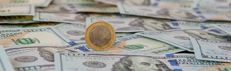 one euro coin against the dollar banknotes.