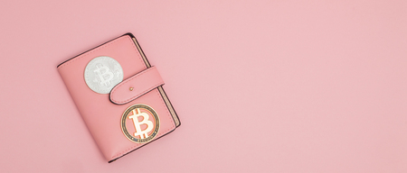 Bitcoins on a pink wallet on the pink background with copy space.の写真素材