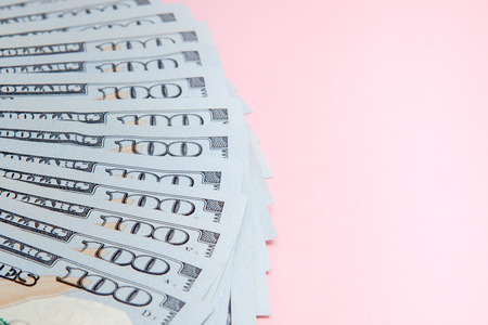 One hundred dollars banknotes on pink background. Flat lay, top view, copy spaceの写真素材