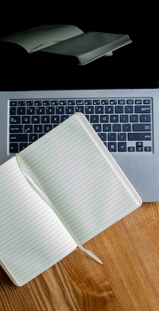 Notepad, laptop on old wooden desk. View from above with copy space in vintage toneの写真素材