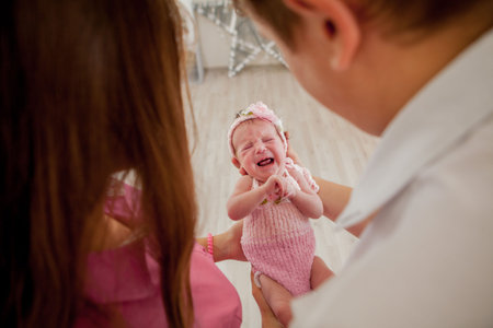 young couple with cute little baby. Smiling mother and father holding their newborn baby daughter at...