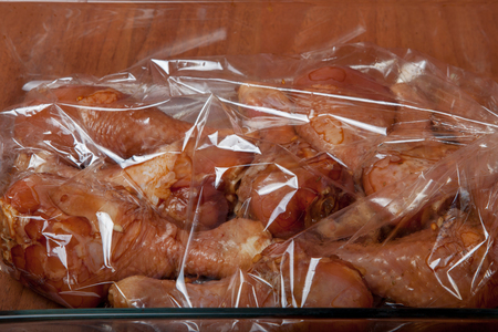 Chicken legs before baking in a baking sackの写真素材