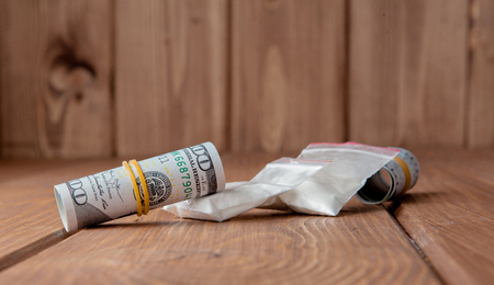 Stack of Money, drugsand on a wooden table. Drug use, crime, addiction and substance abuse concept on wooden background.の写真素材