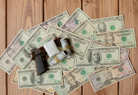 pistols and drugs against the background of dollars.