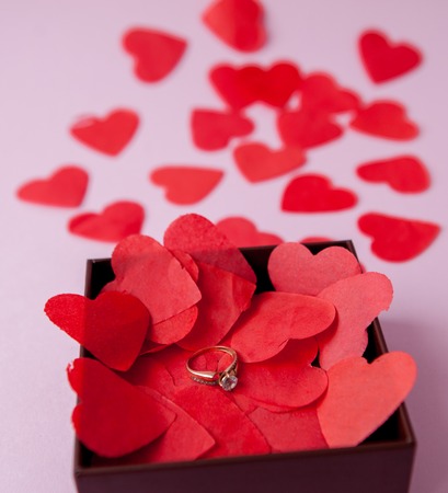 Wedding rings on the red hearts. Pink background. The concept of betrothal, divorce, parting, infidelity .Selective focus.の写真素材
