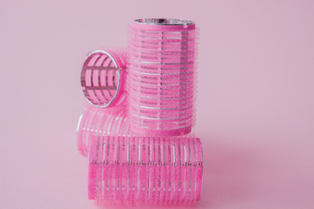 Curlers hair plastic on a pink background with copy space.の写真素材