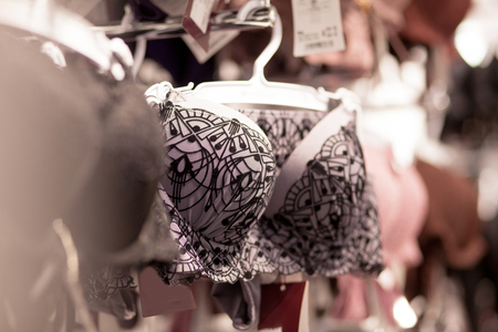 Advertise, Sale, Fashion concept - Close up of woman's hand choosing underwear on hangers in the supermarket.の写真素材