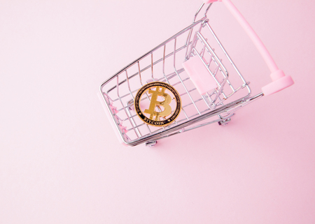 a cart from a supermarket, bitcoin on a wooden background. internet, crypto currency.の写真素材