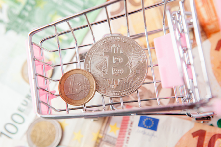 close up toy shopping cart with bitcoin on a euro background, saving money for future, ethereum cryptocurrency, blockchain business technology concept, pink background for text.の写真素材