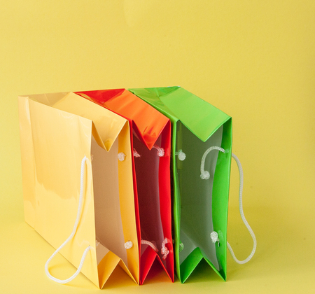 Colorful shopping bagss isolated on yellow background.の写真素材